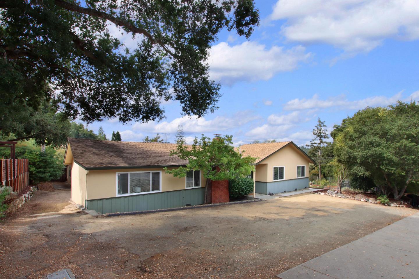 a front view of house with yard and trees in the background