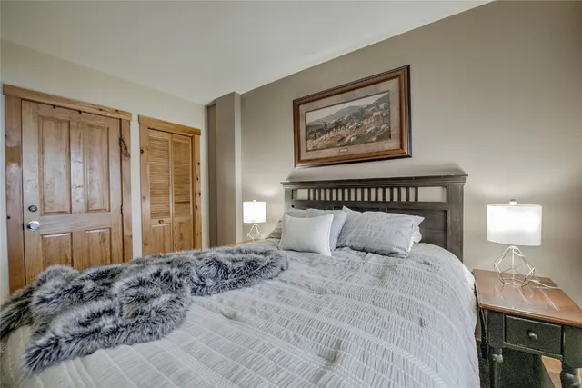 a bedroom with a large bed and a lamp