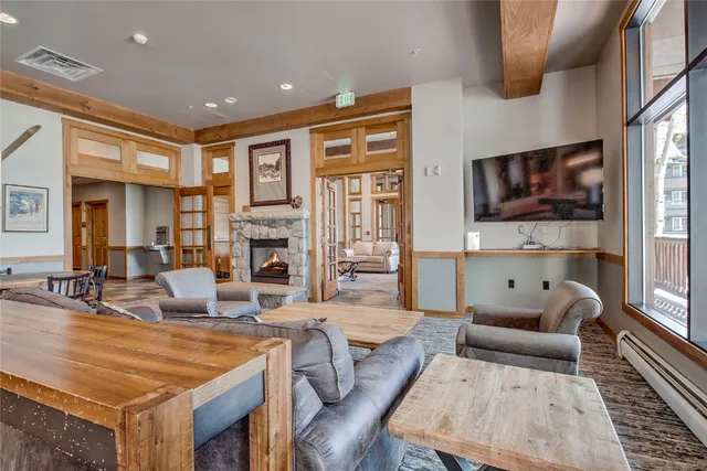 a table and chairs in a room with large mirror