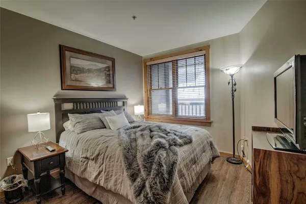 a bedroom with a bed and wooden floor