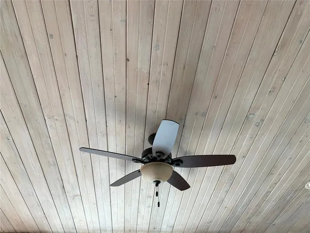 a view of a terrace with lawn chairs and wooden fence