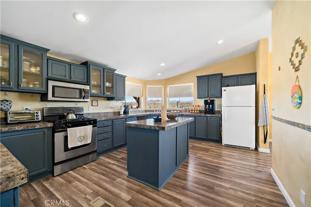 a kitchen with stainless steel appliances granite countertop a stove and a refrigerator