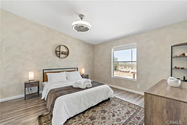 a bed sitting in a spacious bedroom next to a window