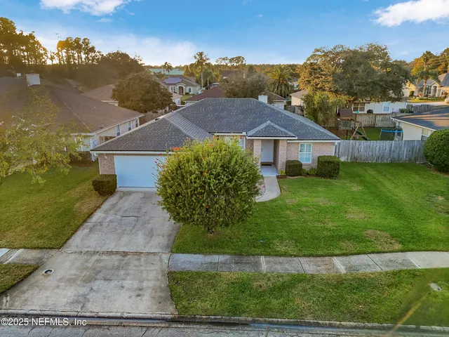 an aerial view of residential houses with outdoor space and trees