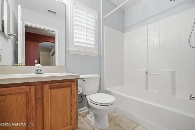 a bathroom with a toilet a sink a mirror and a bathtub