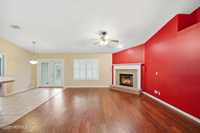 a view of an empty room with a fireplace and a window