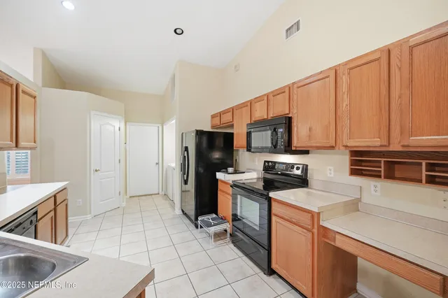 a kitchen with stainless steel appliances kitchen island granite countertop a refrigerator and a stove top oven