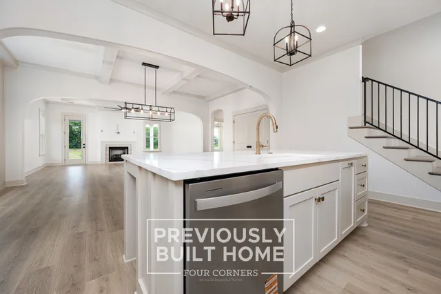 a kitchen with kitchen island granite countertop a sink cabinets and wooden floor