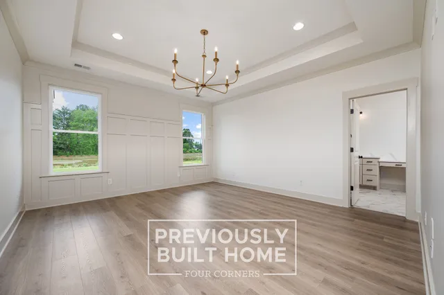 a view of a hallway with wooden floor and a large space