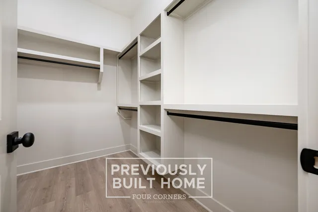 a view of walk in closet with empty racks
