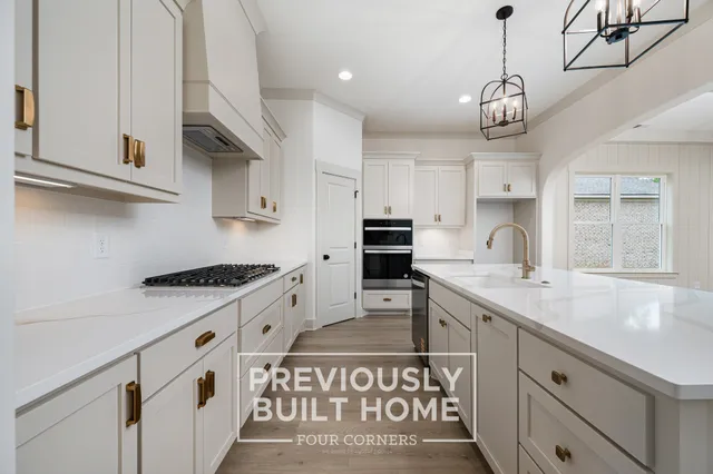 a kitchen with stainless steel appliances granite countertop a sink a stove and a refrigerator