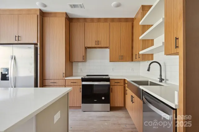 a kitchen with stainless steel appliances granite countertop a sink stove and refrigerator