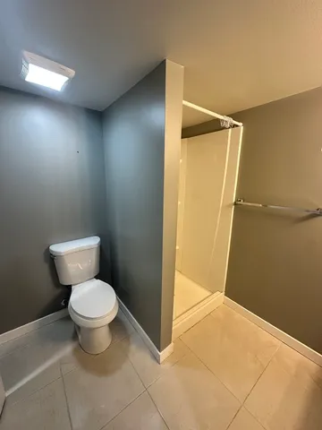 a bathroom with a toilet and a shower