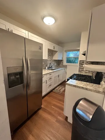 a kitchen with stainless steel appliances granite countertop a refrigerator a sink and a stove