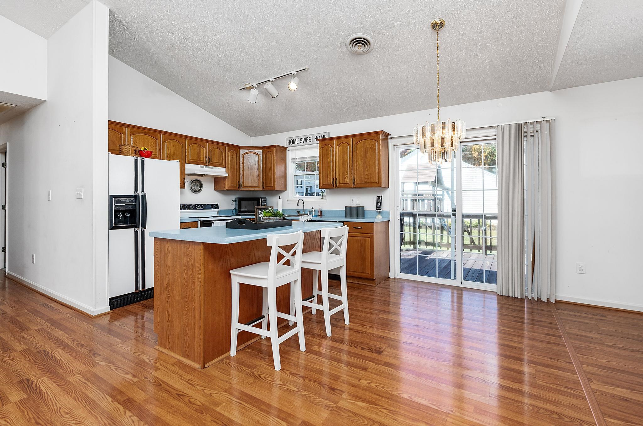300 Robinhood Road Staunton, VA 24401 - Photo 8 of 51 a kitchen with stainless steel appliances kitchen island granite countertop a refrigerator a stove a microwave oven a dining table and chairs with wooden floor