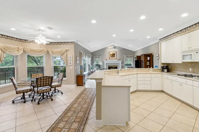 a kitchen with a refrigerator a stove top oven and a sink with couches