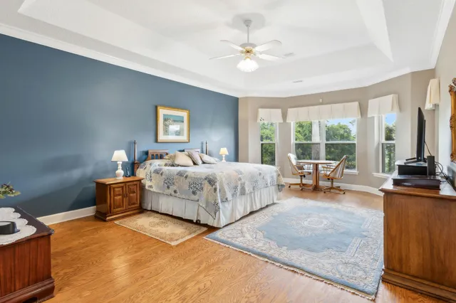 a large bedroom with a bed and wooden floor