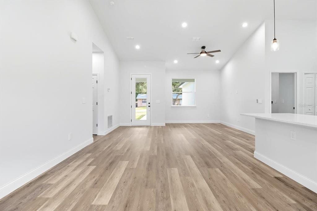 6716 East Crimson Lane Inverness, FL 34452 - Photo 12 of 44 an empty room with wooden floor and windows