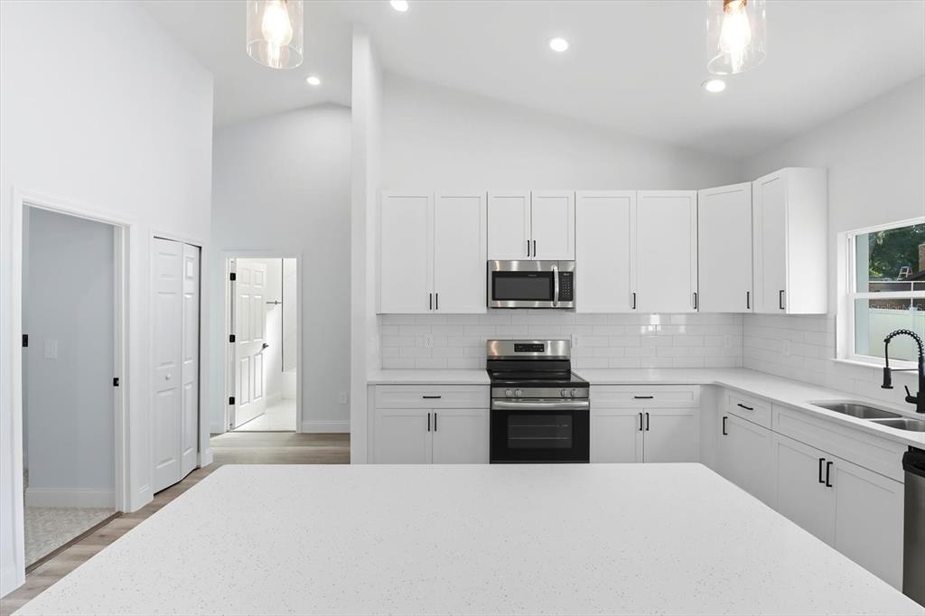 6716 East Crimson Lane Inverness, FL 34452 - Photo 14 of 44 a large white kitchen with stainless steel appliances