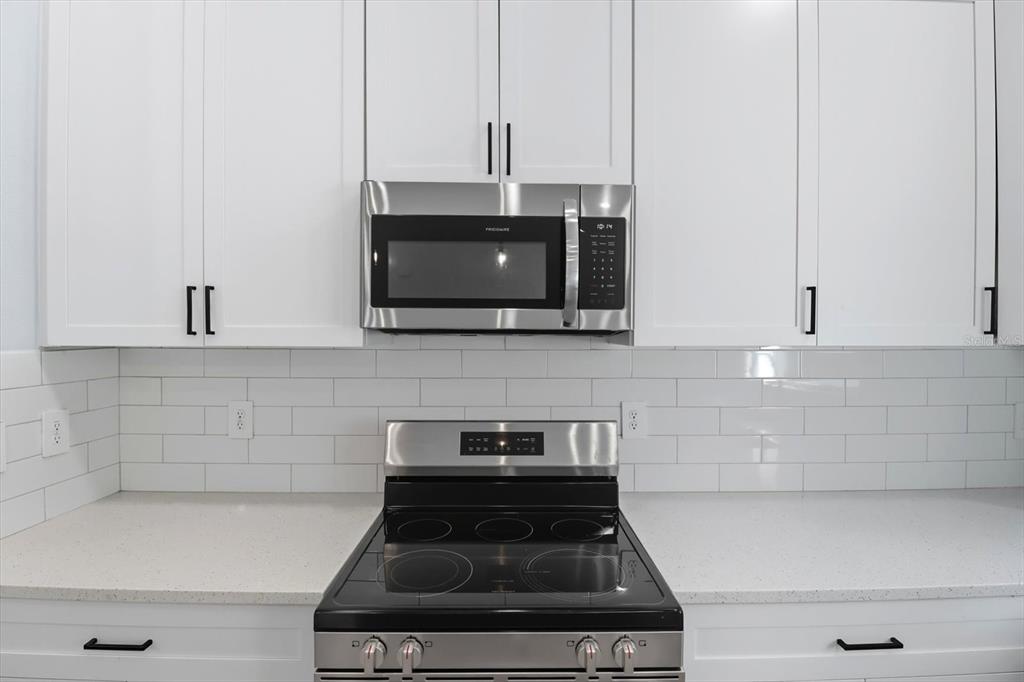 6716 East Crimson Lane Inverness, FL 34452 - Photo 17 of 44 a kitchen with stainless steel appliances granite countertop white cabinets and a stove top oven