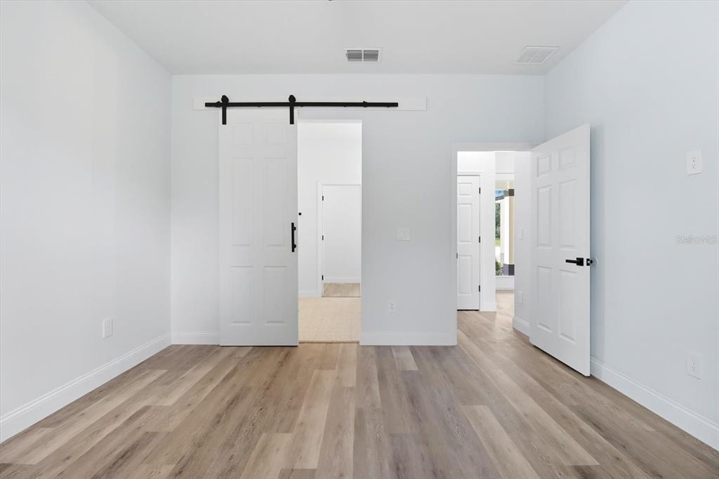 6716 East Crimson Lane Inverness, FL 34452 - Photo 22 of 44 a view of a room with wooden floor and a ceiling fan