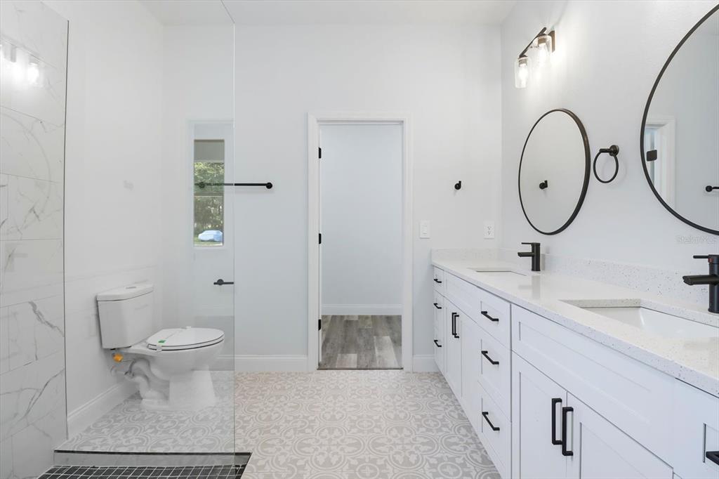 6716 East Crimson Lane Inverness, FL 34452 - Photo 23 of 44 a bathroom with a double vanity sink toilet and a mirror