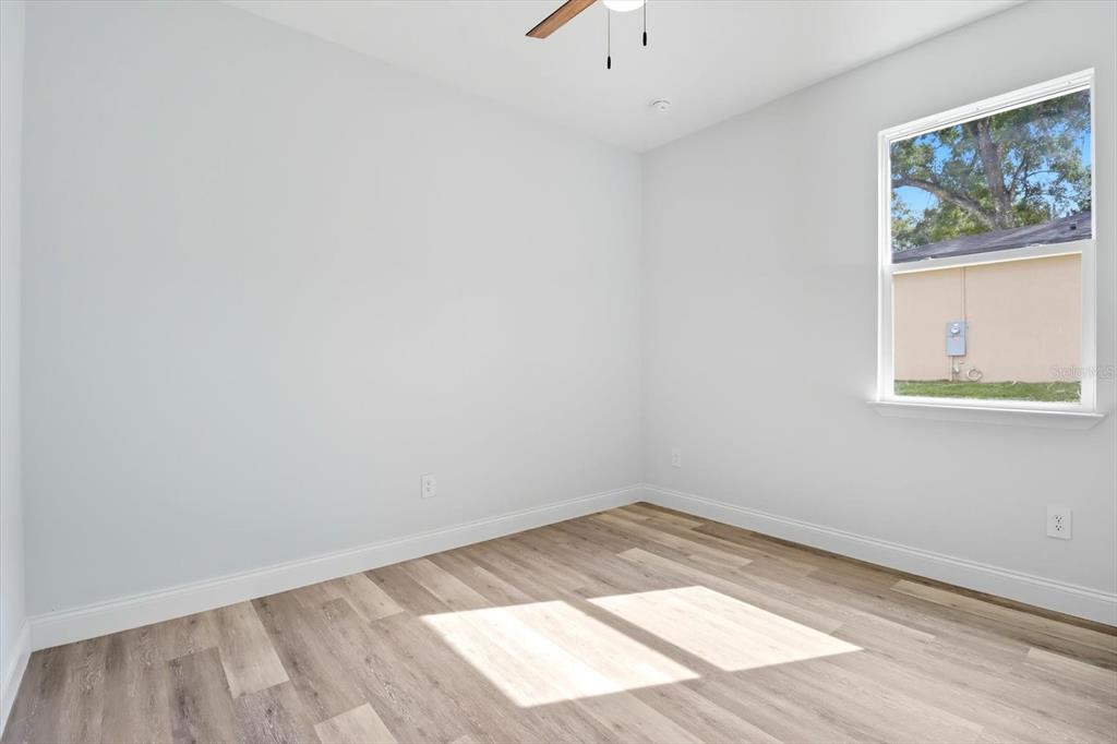 6716 East Crimson Lane Inverness, FL 34452 - Photo 32 of 44 an empty room with wooden floor and windows
