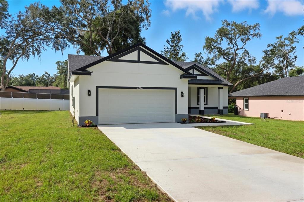 6716 East Crimson Lane Inverness, FL 34452 - Photo 5 of 44 a front view of house with yard and trees in the background