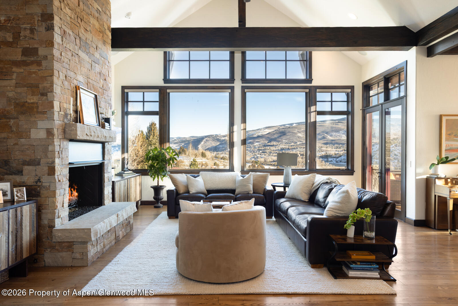 a living room with furniture large windows and a fireplace