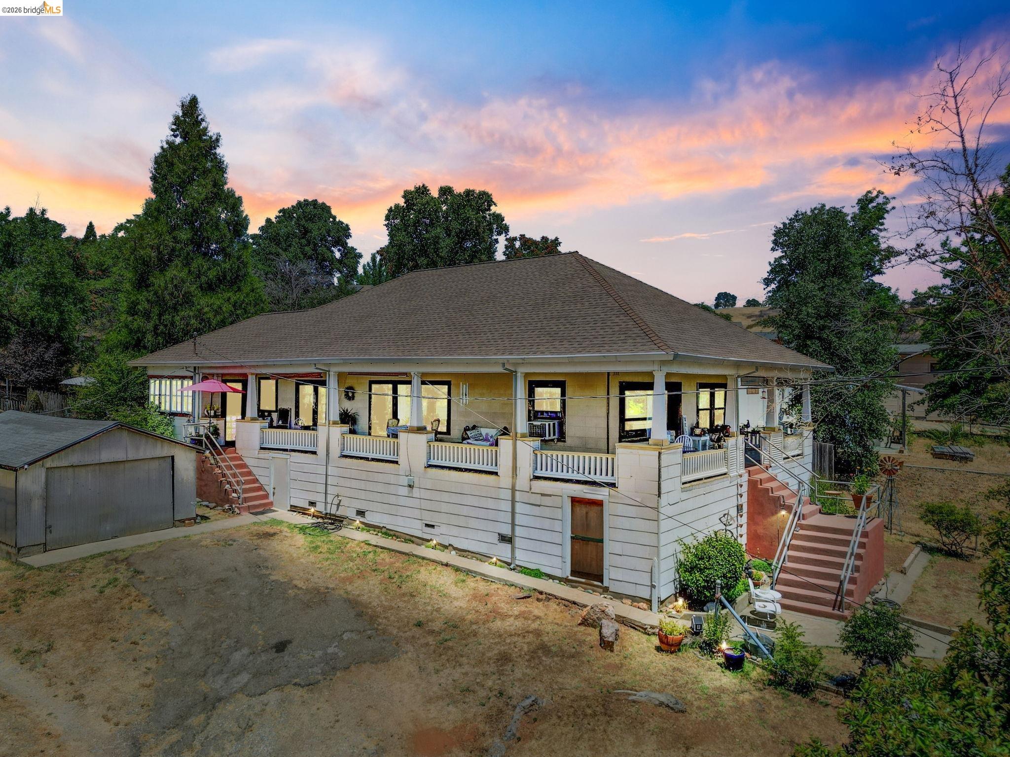 View of front of property with stairs, covered porch, and an outdoor structure
