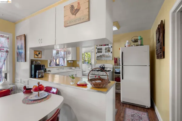 a kitchen with a refrigerator a stove and a dining table