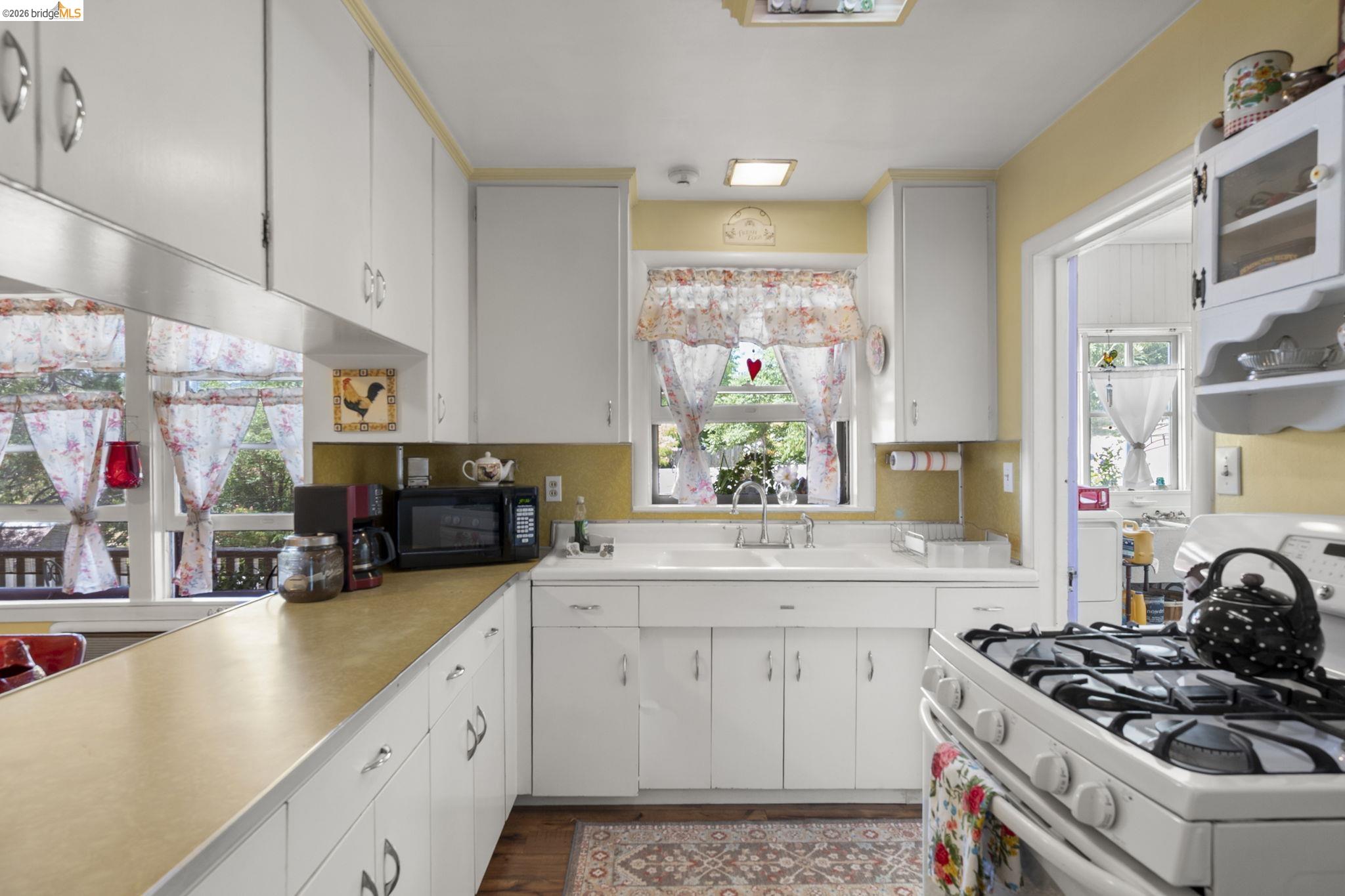 213 Main Street San Andreas, CA 95249 - Photo 20 of 55 Kitchen featuring vintage white range with gas stovetop, light countertops, white cabinets, wood finished floors