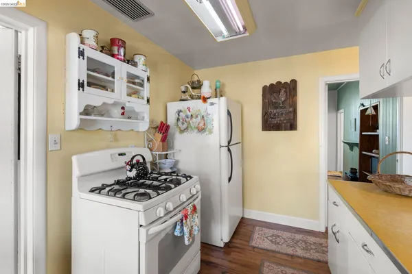 a kitchen with a refrigerator and a stove top oven