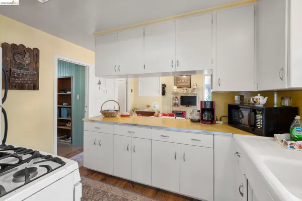a kitchen with white cabinets and appliances