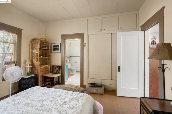 a bedroom with a bed and a large mirror on the dresser