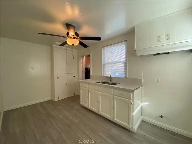 a kitchen with a sink cabinets and wooden floor