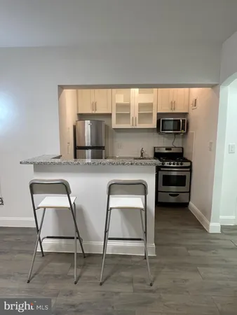 a kitchen with stainless steel appliances a microwave a stove and white cabinets