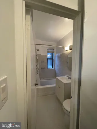 a bathroom with a granite countertop sink a toilet and shower