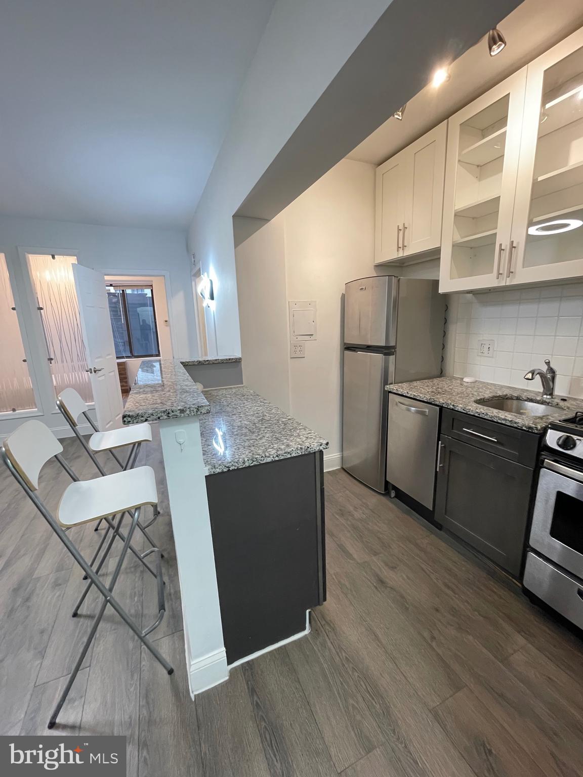 1 Scott Circle Northwest, Unit 118 Washington, DC 20005 - Photo 9 of 35 a kitchen with stainless steel appliances granite countertop a refrigerator a sink dishwasher a stove with wooden floors and cabinets