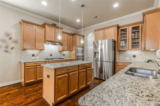 a kitchen with stainless steel appliances granite countertop a sink stove and refrigerator