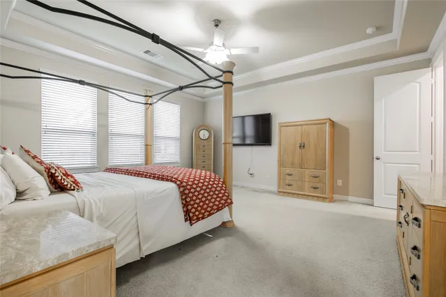 a bedroom with bed dresser and flat screen tv