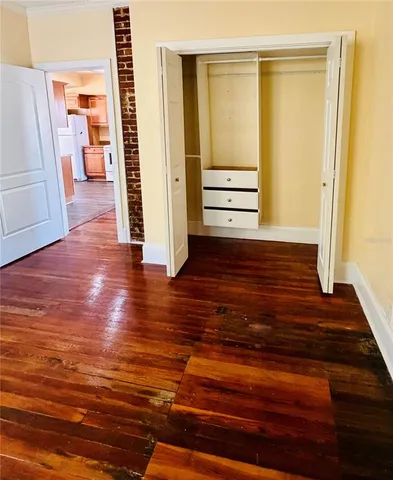 a view of a hallway with wooden floor and stairs
