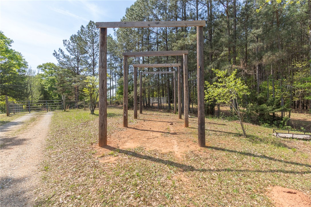 820 Travis Road Anderson, SC 29626 - Photo 46 of 46 This verdant expanse features rustic wooden archways and a serene, tree-lined backdrop.