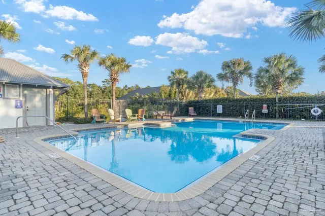 an aerial view of a house with swimming pool a yard and a patio