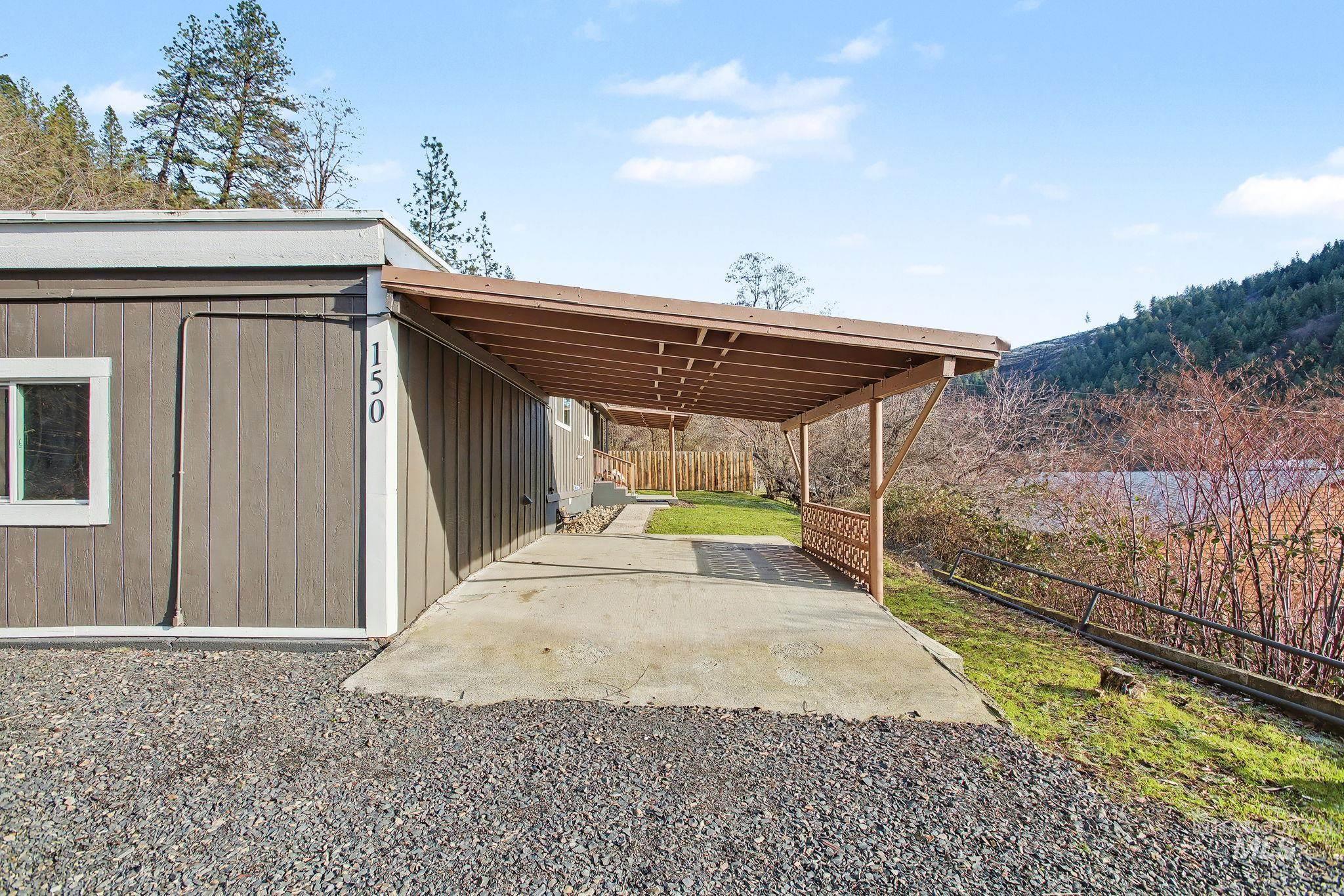150 Elm Street Orofino, ID 83544 - Photo 25 of 36 Carport structure with a concrete pad and gravel driveway