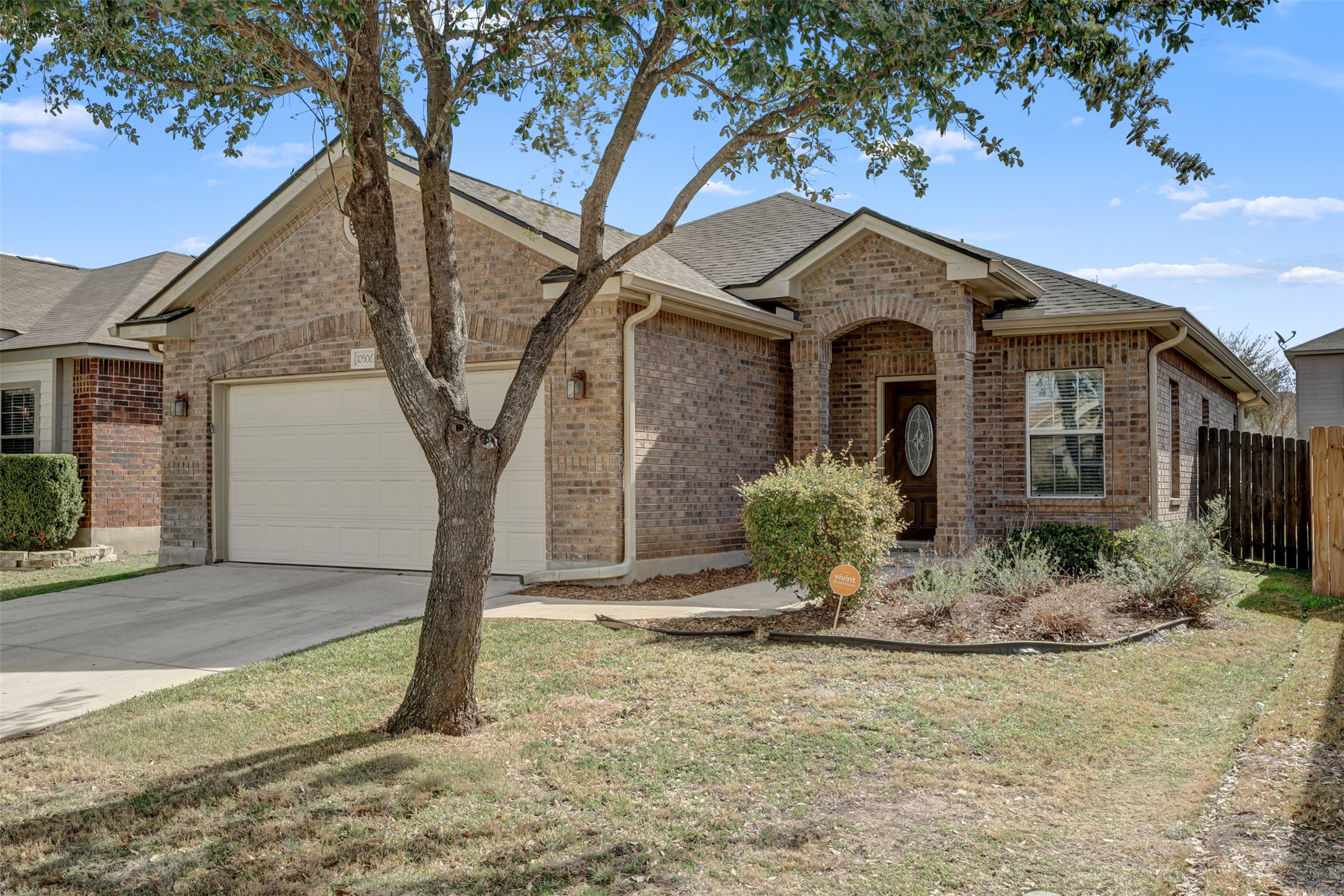 10506 Corvey Lane Helotes, TX 78023 - Photo 2 of 28 Single story home with an attached garage, brick siding, concrete driveway, and roof with shingles