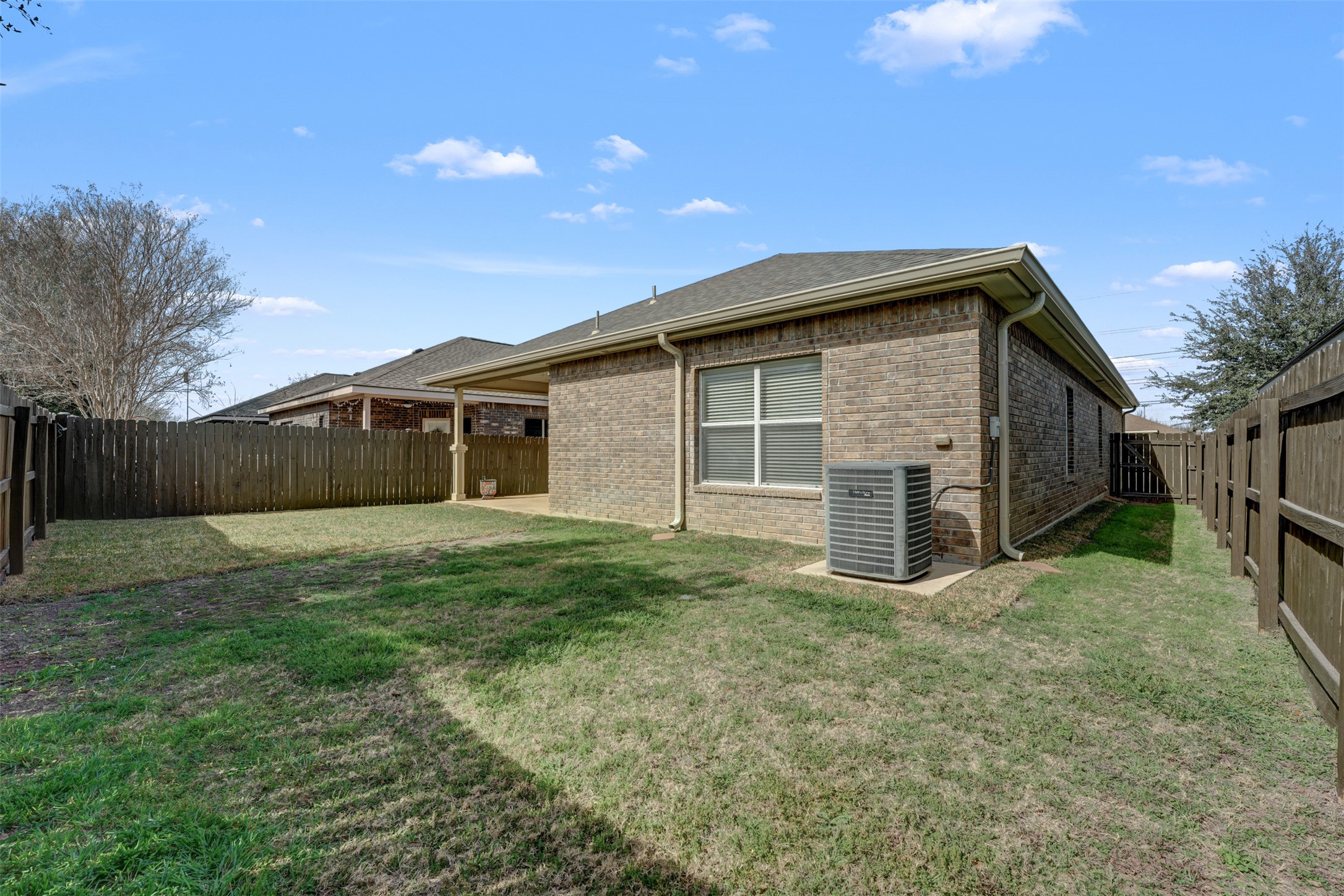 10506 Corvey Lane Helotes, TX 78023 - Photo 24 of 28 Rear view of house featuring brick siding, a fenced backyard, and a patio