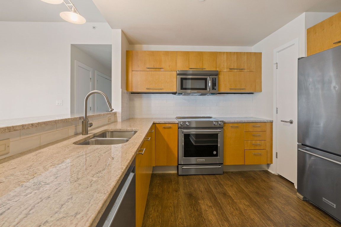 603 Davis Street, Unit 1304 Austin, TX 78701 - Photo 11 of 40 a kitchen with stainless steel appliances a stove a sink and a microwave