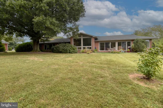 a front view of house with yard and trees around