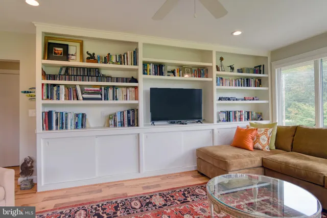 a living room with furniture and a book shelf